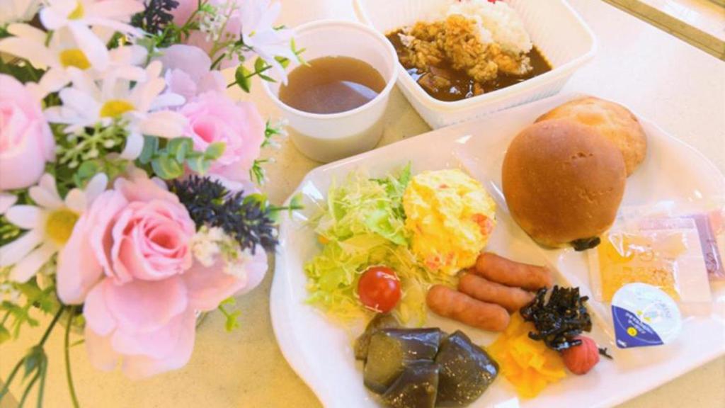 a white plate of food with a sandwich and vegetables at Toyoko Inn Osaka Itami Airport in Toyonaka