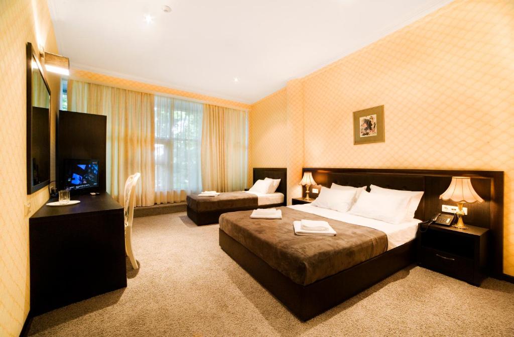 a large hotel room with a bed and a couch at Kalasi Hotel in Tbilisi City