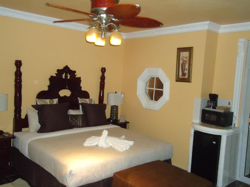 a bedroom with a bed with a ceiling fan at Cas Bed & Breakfast in Falmouth