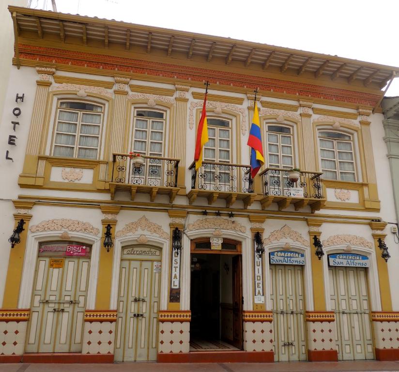 un edificio con dos banderas encima en Hotel La Orquidea en Cuenca
