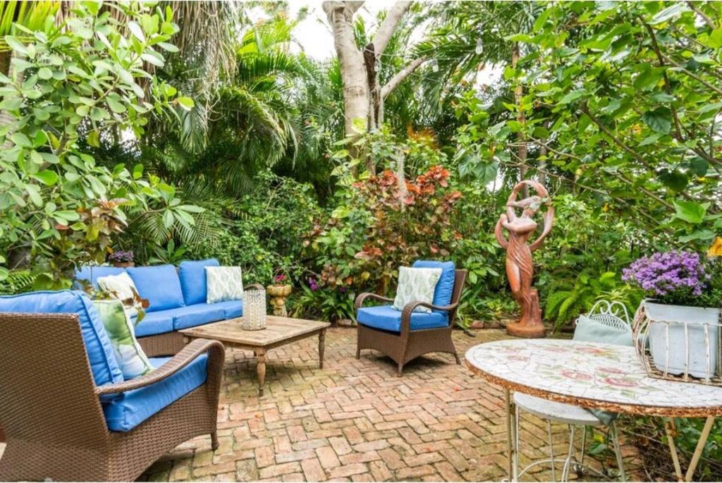 un patio con mobili blu, tavolo e sedie di Chateau Gardens a Lake Worth