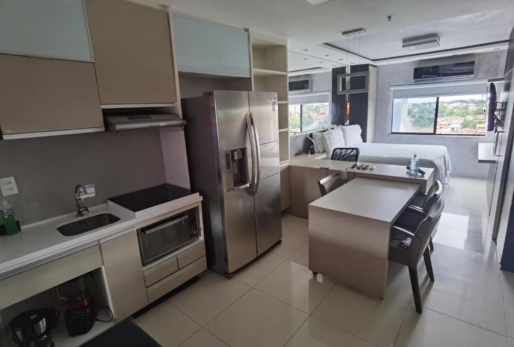 a kitchen with stainless steel appliances and a bed at Flat Apartamento ALTÍSSIMO NÍVEL Último Andar in Teresina