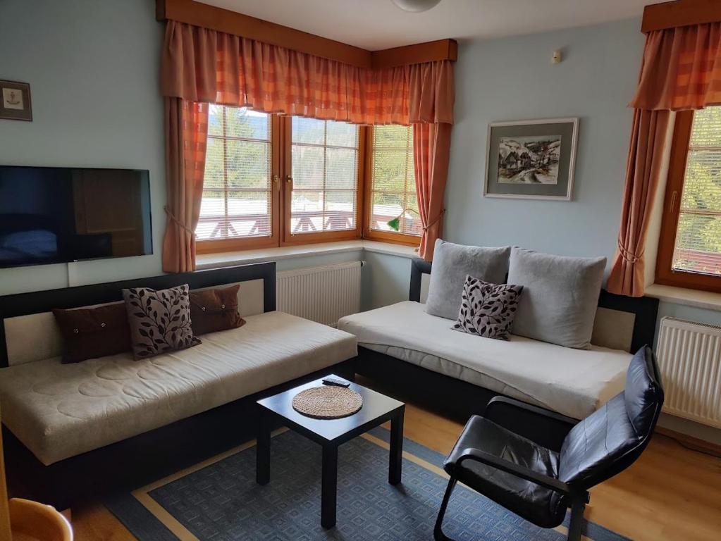 uma sala de estar com dois sofás e uma mesa em Pension Kubů Apartment 4 samostatný byt s kuchyní em Spindleruv Mlyn