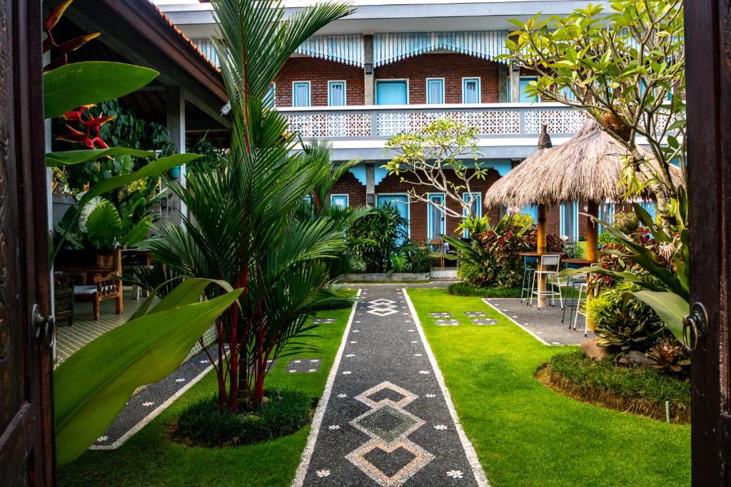a courtyard of a hotel with plants and grass at D-Anyar Stay and Surf Canggu in Canggu