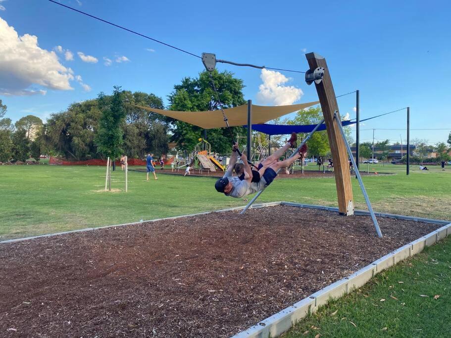 a person is hanging on a swing in a park at Popular Central Location I NEW LINEN I Gated Estate I STAY DUBBO in Dubbo