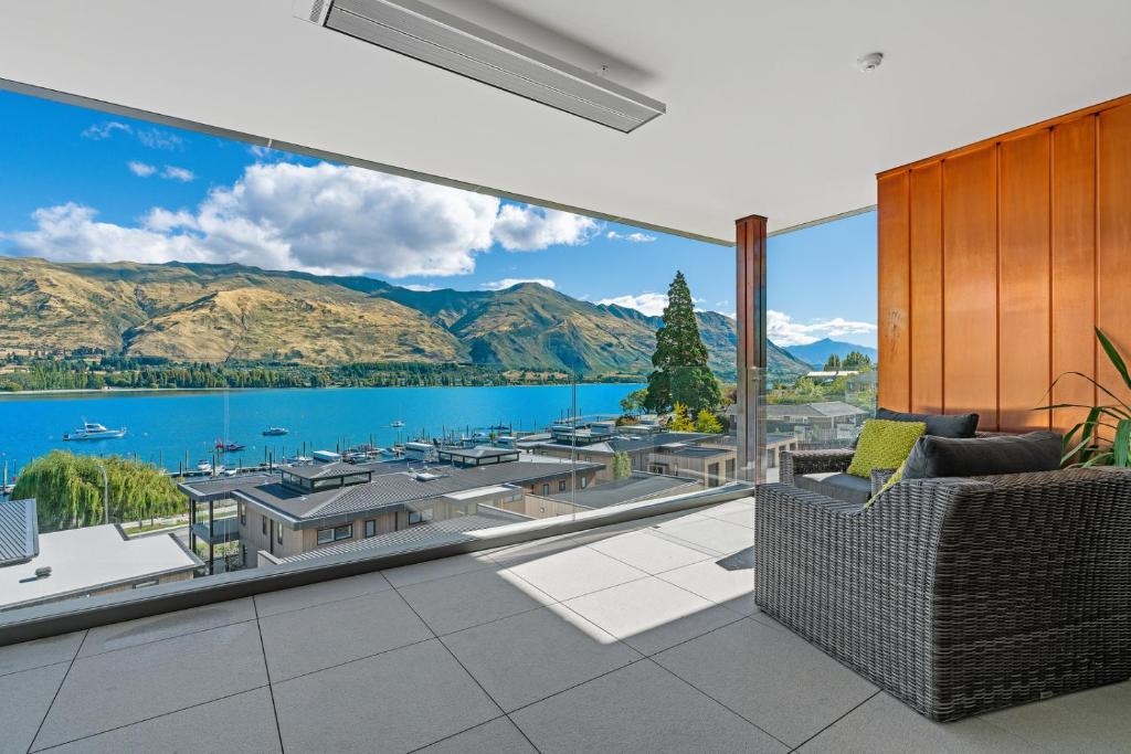 a living room with a view of the water and mountains at Luxurious Lakefront Penthouse in Wanaka