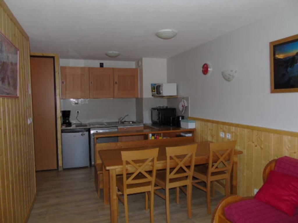 uma cozinha e sala de jantar com mesa e cadeiras em Appartement Valfréjus, 2 pièces, 6 personnes - FR-1-561-93 em Valfréjus