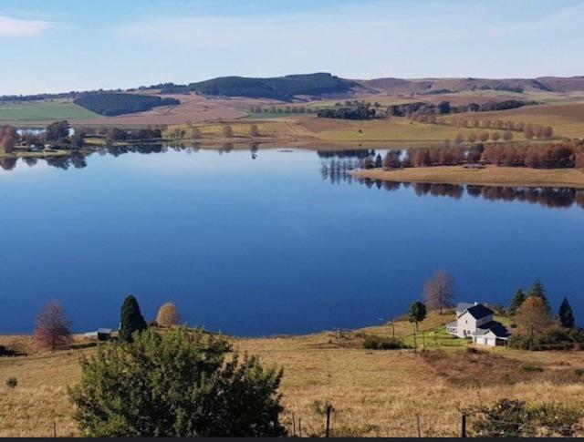 a large lake with a house in the middle of a field at Lakeside Cottage on Spring Grove in Nottingham Road