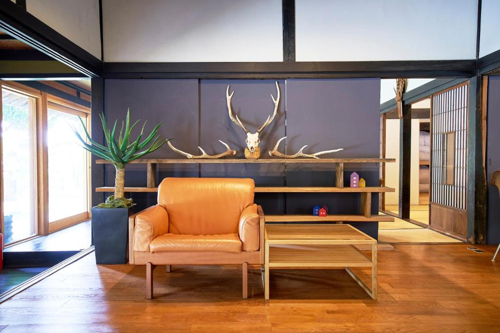 福山的住宿－せとうち母家 Setouchi OMOYA，客厅配有橙色椅子和桌子