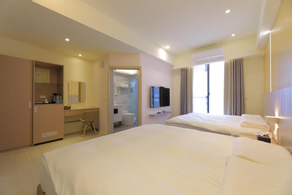 a hotel room with a large bed and a bathroom at Donghao Hotel in Yuli