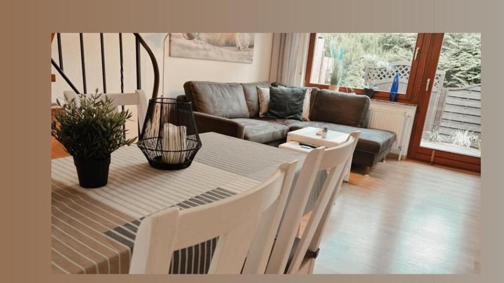 sala de estar con mesa y sofá en Kleine Robbe Ferienhaus, en Dangast
