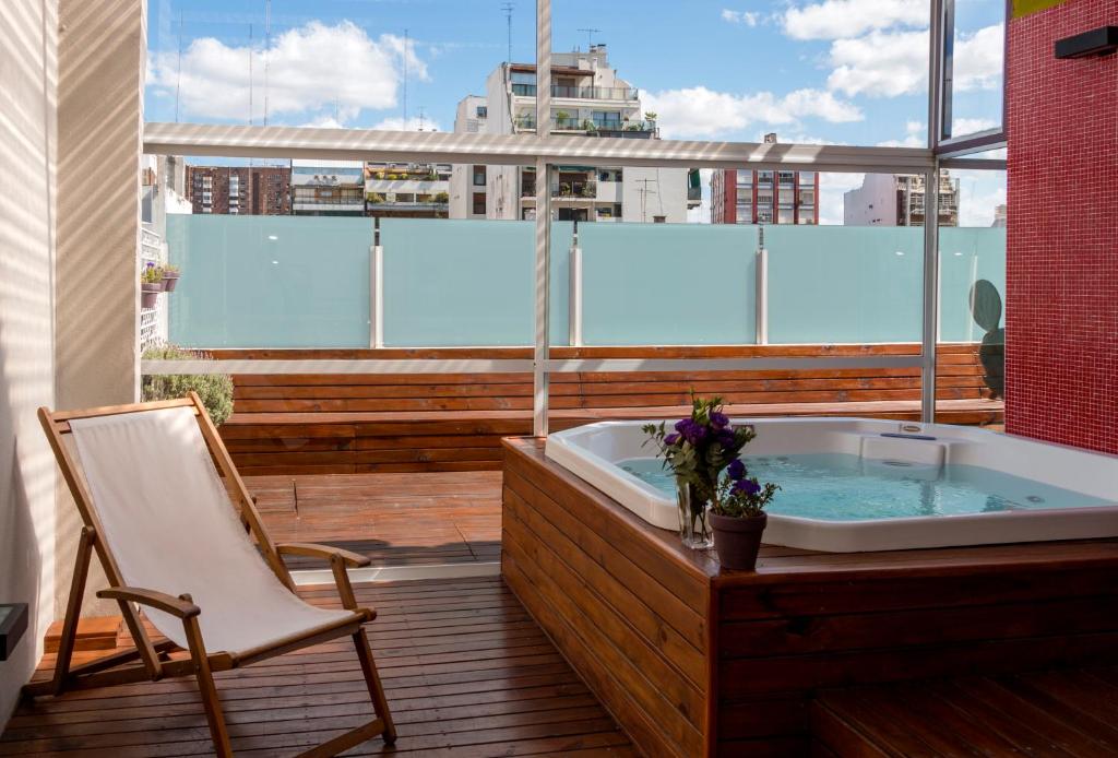 a bath tub sitting on a balcony with a chair at Infinito Hotel in Buenos Aires
