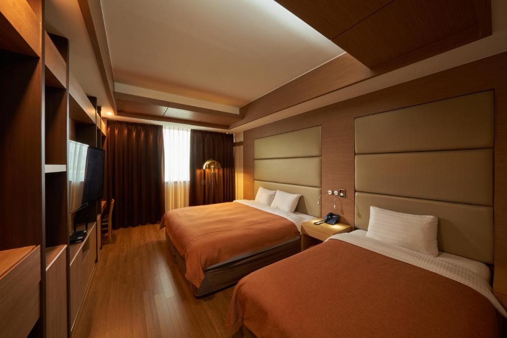 Postel nebo postele na pokoji v ubytování Gyeongju GG Tourist Hotel