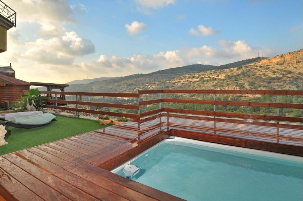 a hot tub on the deck of a house at Caves of Genesis in Ya‘ara