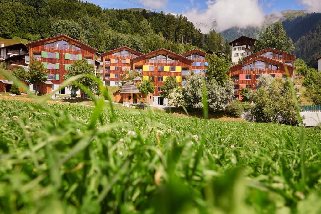 ein Resort in den Bergen mit einem Grasfeld in der Unterkunft Reka-Feriendorf Disentis in Disentis