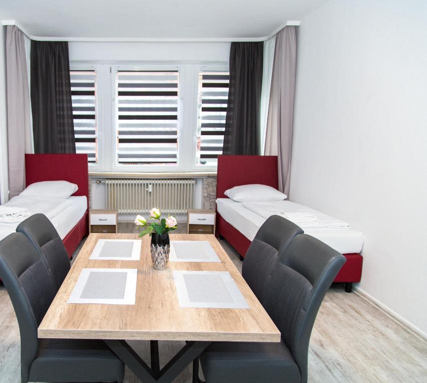 a room with two beds and a table and chairs at Othman Appartements Falkenstraße 26 3OG L in Hannover