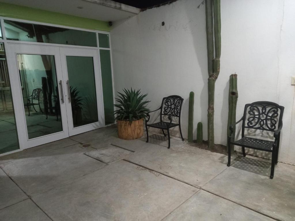 two chairs sitting on a patio with glass doors at Casa Ejutla de Crespo, Oaxaca 