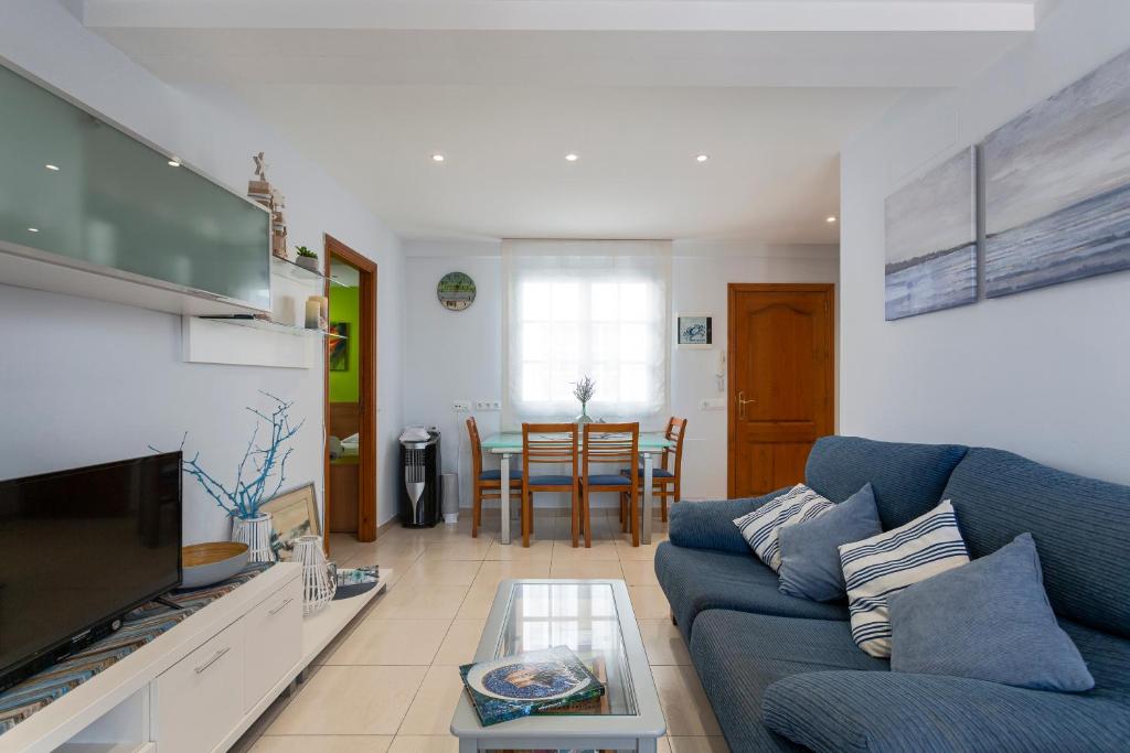 ein Wohnzimmer mit einem blauen Sofa und einem Tisch in der Unterkunft Apartament Sant Antoni de Calonge in Sant Antoni de Calonge