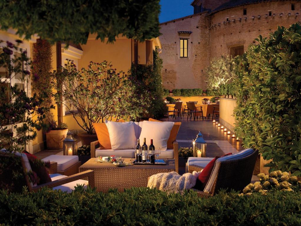 eine Außenterrasse mit Sofas und einem Tisch mit Beleuchtung in der Unterkunft Hotel Capo d´África – Colosseo in Rom