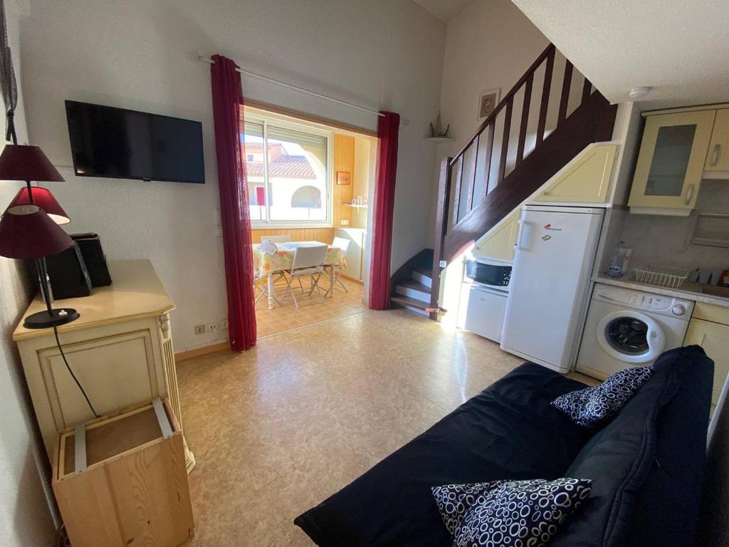 Il comprend un salon avec un canapé et une cuisine avec un escalier. dans l'établissement Appartement T2+Mezzanine, 6 pers, Clim, Parking, 400m des commerces - FR-1-81-562, à Port-Leucate