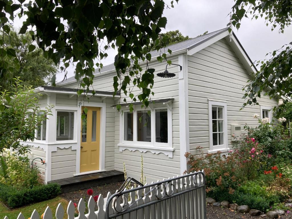 una casa bianca con una porta gialla di Country Bliss Cottage a Greytown
