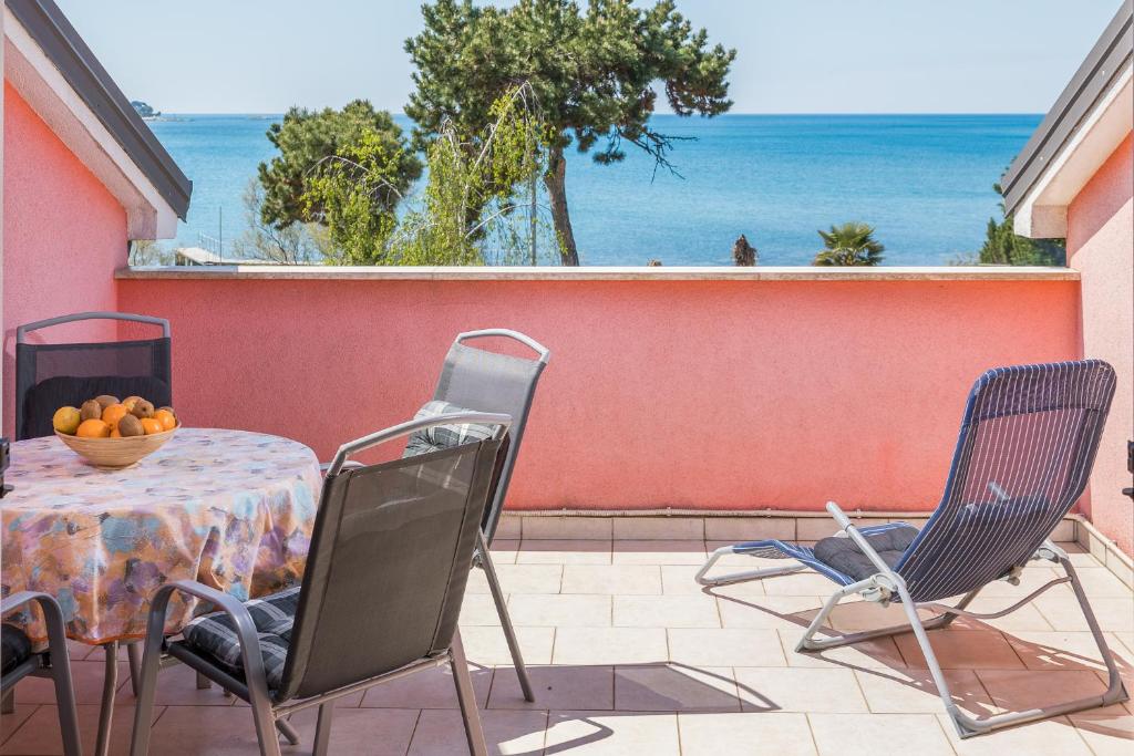 een tafel en stoelen op een patio met uitzicht op de oceaan bij Sea Star with Stunning Sea View in Poreč