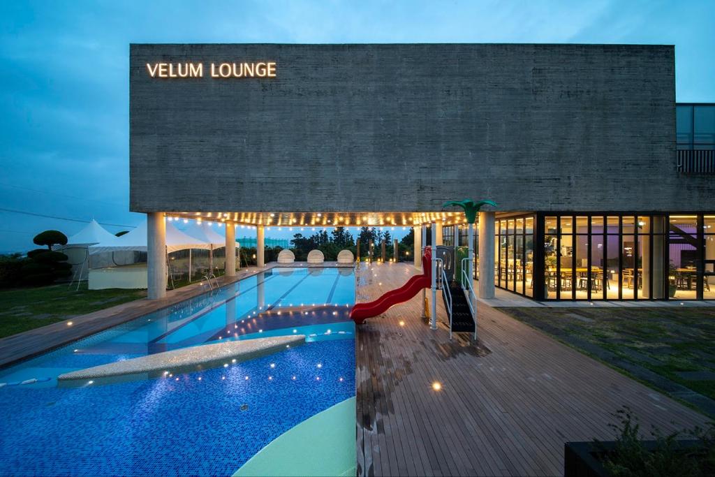 a large swimming pool in front of a building at Velum Resort in Seogwipo
