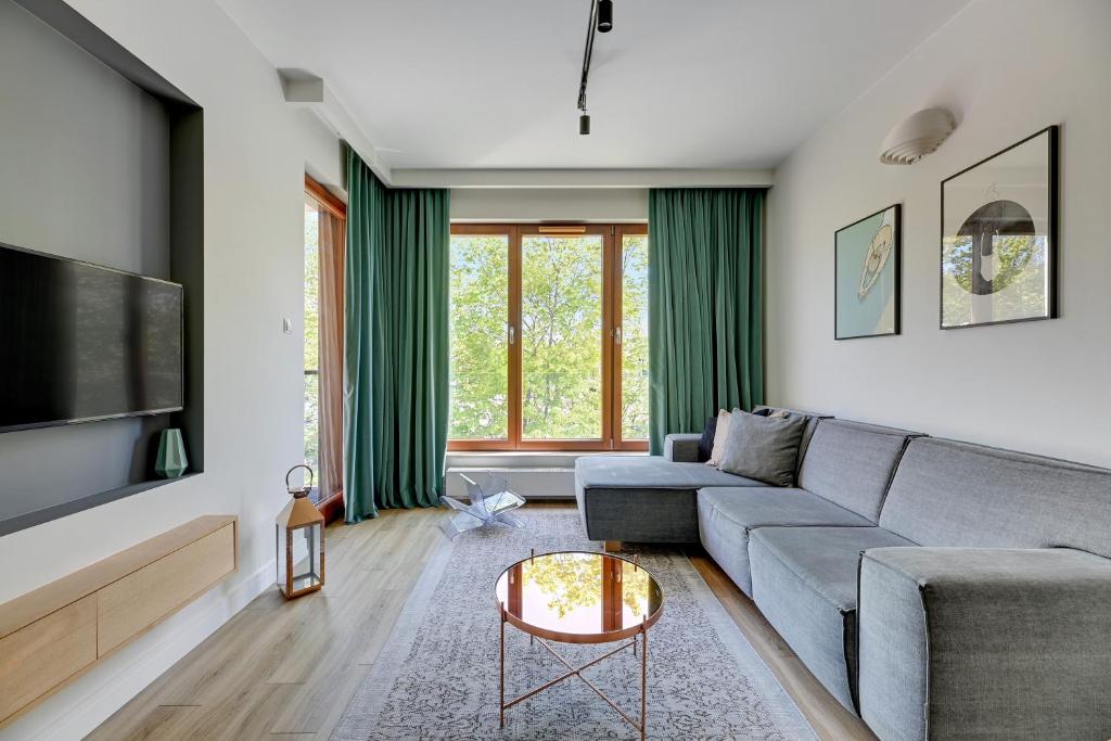 a living room with a couch and a table at Downtown Apartments Gdynia Seaside Nowe Orłowo in Gdynia