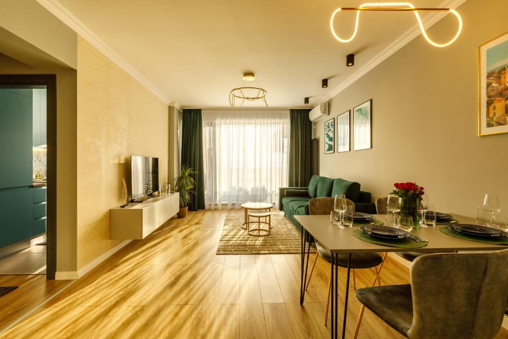 a living room with a table and a dining room at Lago Apartment Mamaia Butoaie in Mamaia