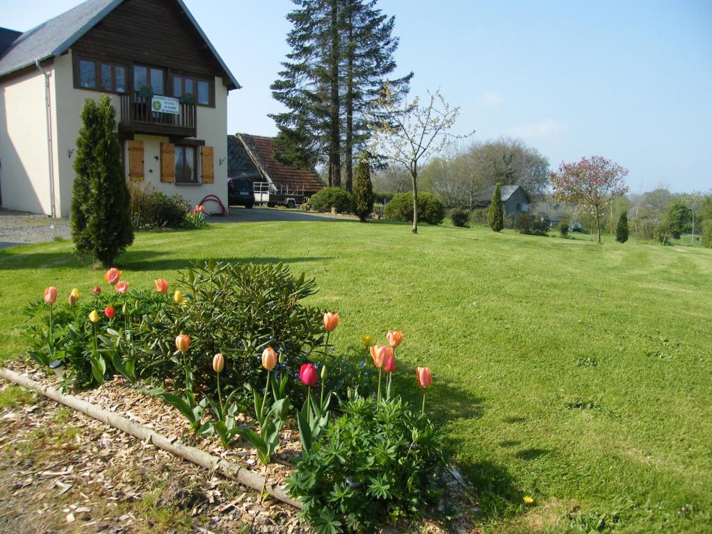 einen Garten mit rosa Blumen in einem Hof mit einem Haus in der Unterkunft La Ferme de Montaigu in Montaigu-les-Bois