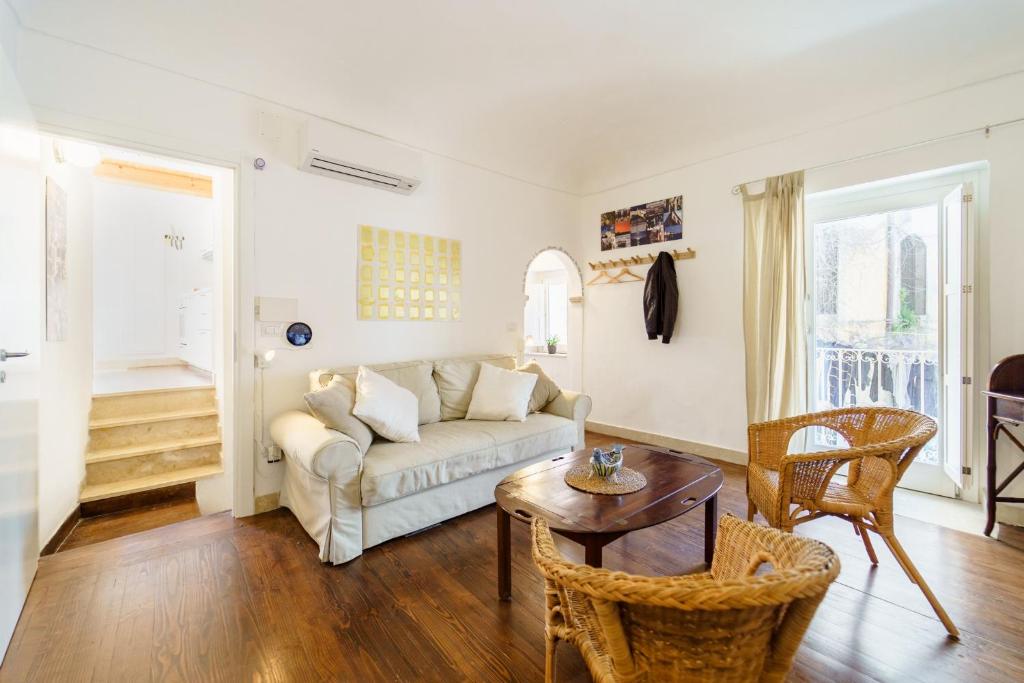 ein Wohnzimmer mit einem Sofa und einem Tisch in der Unterkunft Ortigia Colourful Apartment in Syrakus