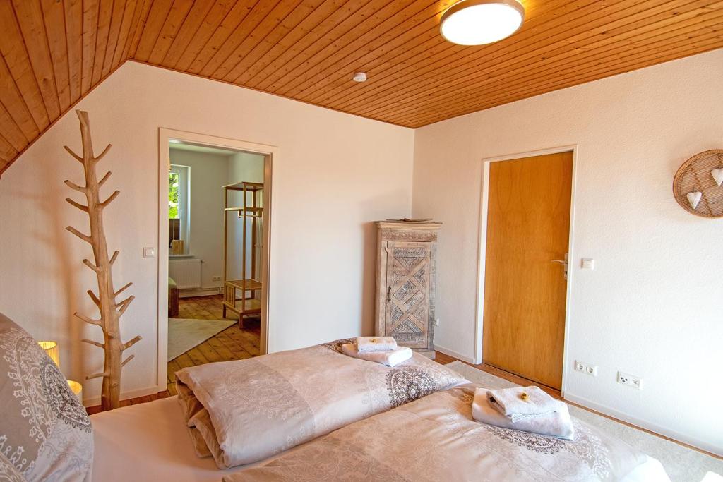 a bedroom with a bed and a wooden ceiling at Ferienhäuser Rosalinn und Felinchen in Eutin