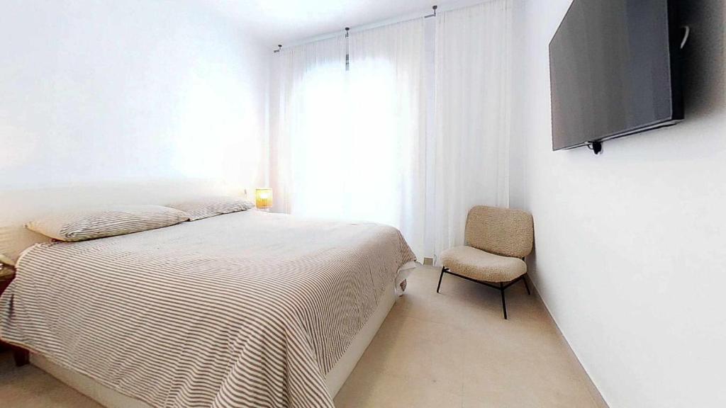 A bed or beds in a room at Precioso ático en edificio Nuevo Juzgado