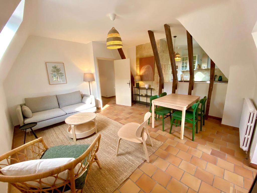 a living room with a couch and a table at Les Courtines - Appartement de caractère à la Roque-Gageac - Les Cerisiers in La Roque-Gageac