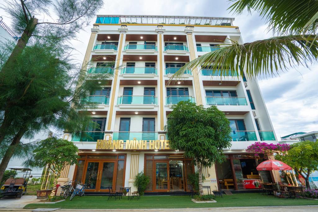 - un grand bâtiment blanc avec un panneau dans l'établissement HOẰNG MINH HOTEL, à Sầm Sơn