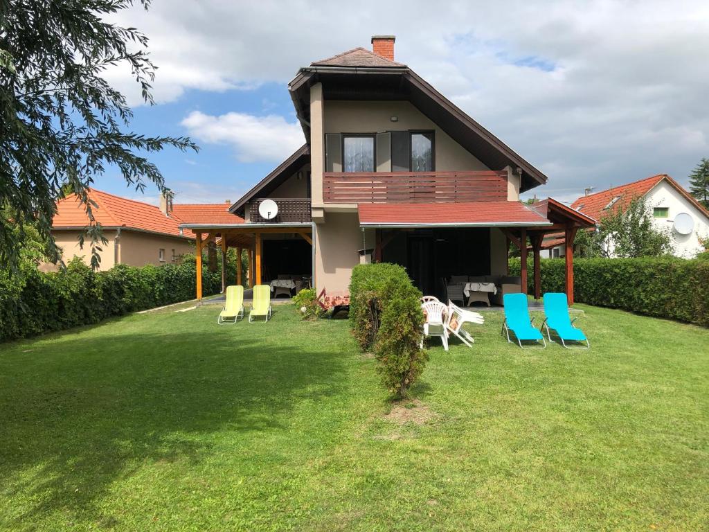 a house with chairs on the lawn at Mária Villa in Balatonmáriafürdő