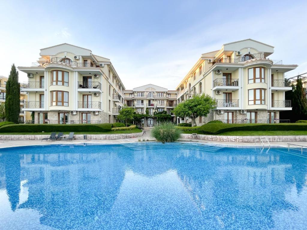 a large swimming pool in front of two large apartment buildings at Royal Bay Apartments with Self Check-in in Sveti Vlas