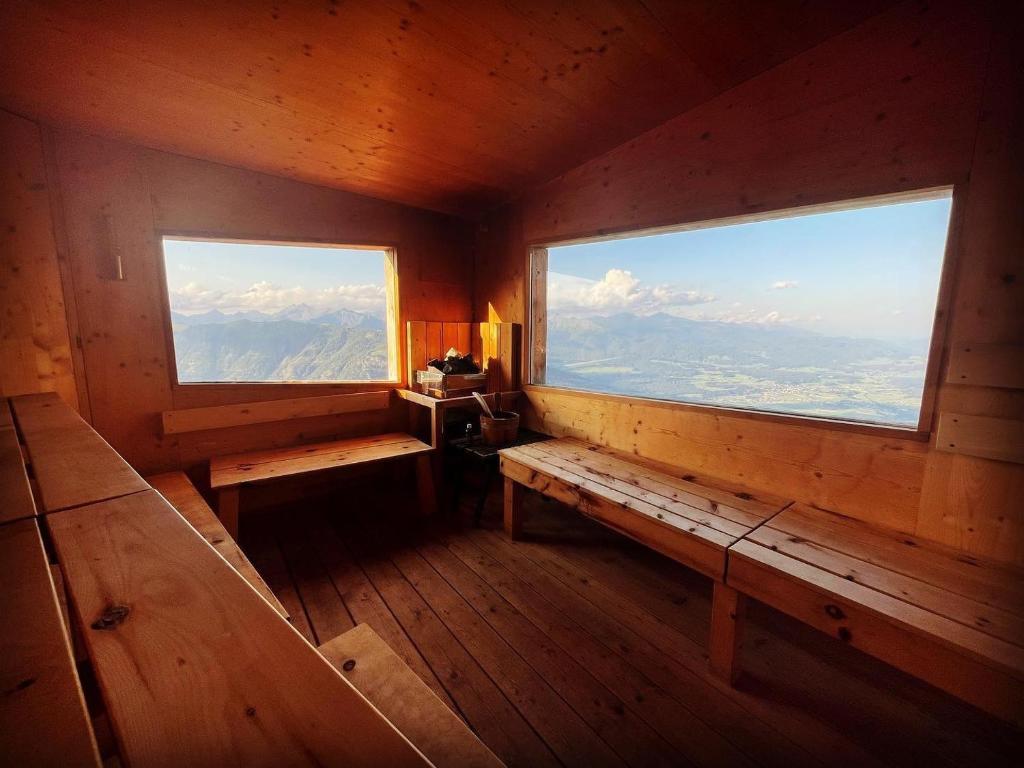 an empty room with a bench and two windows at Speiereckhütte in Mauterndorf