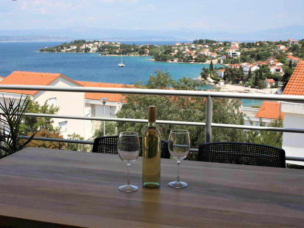 a bottle of wine and two glasses on a table at Apartman I & R in Nečujam