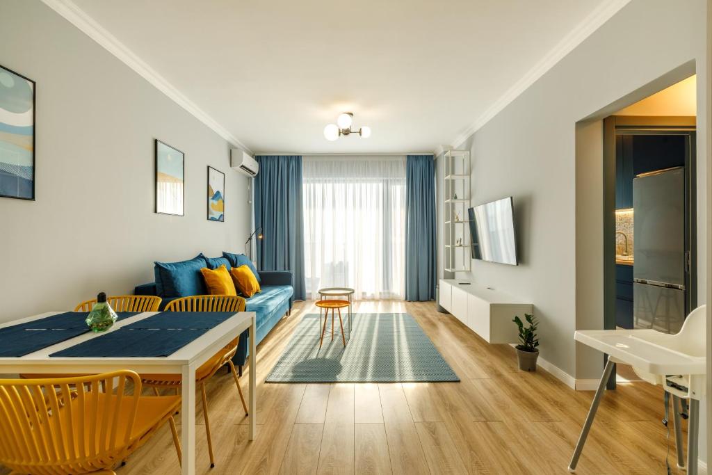 ein Wohnzimmer mit einem blauen Sofa und einem Tisch in der Unterkunft Lucky 13 in Mamaia