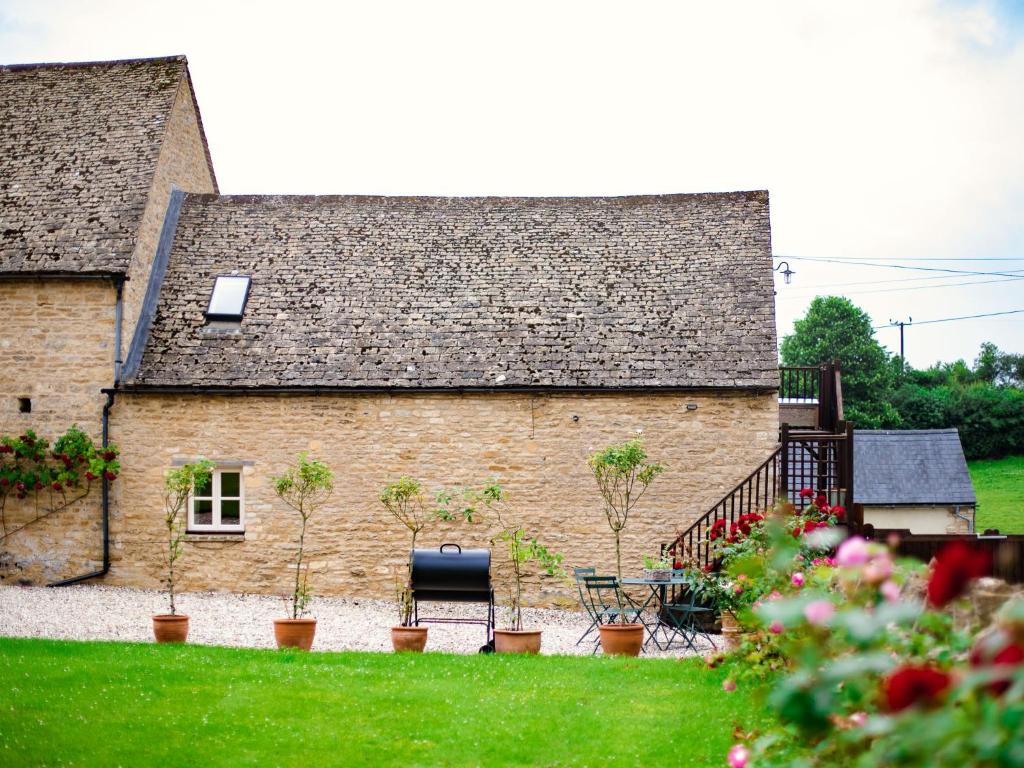 an old stone building with plants in front of it at Hayloft at NewBarn Farm in Chipping Norton