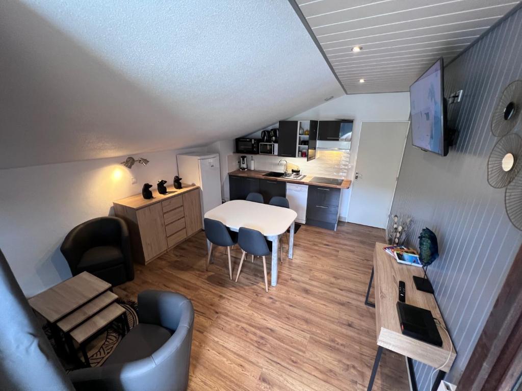 a living room and kitchen with a table and chairs at les cristallines in Le Lioran