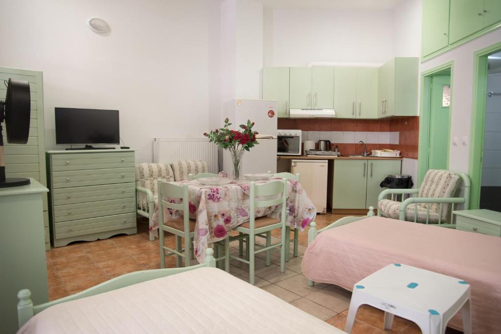 een kamer met een tafel en stoelen en een keuken bij STAVROS Studio Apartment in kos town in Kos-stad
