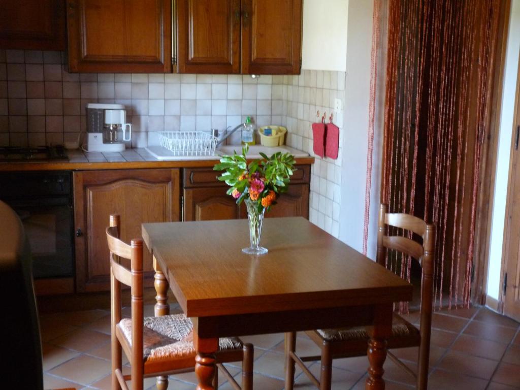 a kitchen with a table with a vase of flowers on it at Mas des Esclots in Nîmes