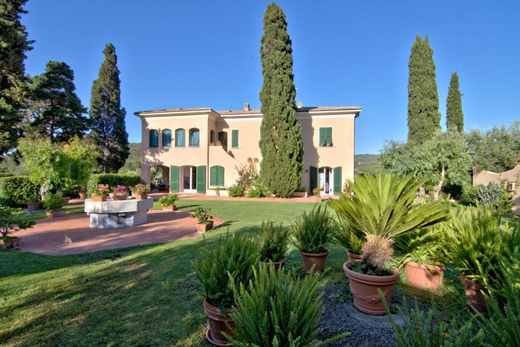 ein großes Haus mit Bäumen und Pflanzen im Hof in der Unterkunft Residenza La Limonaia in Portoferraio