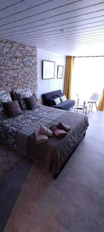 sypialnia z dużym łóżkiem i kapciami w obiekcie LE COSY Joli F2 proche gare, Arénes avec terrasse privée w mieście Nîmes
