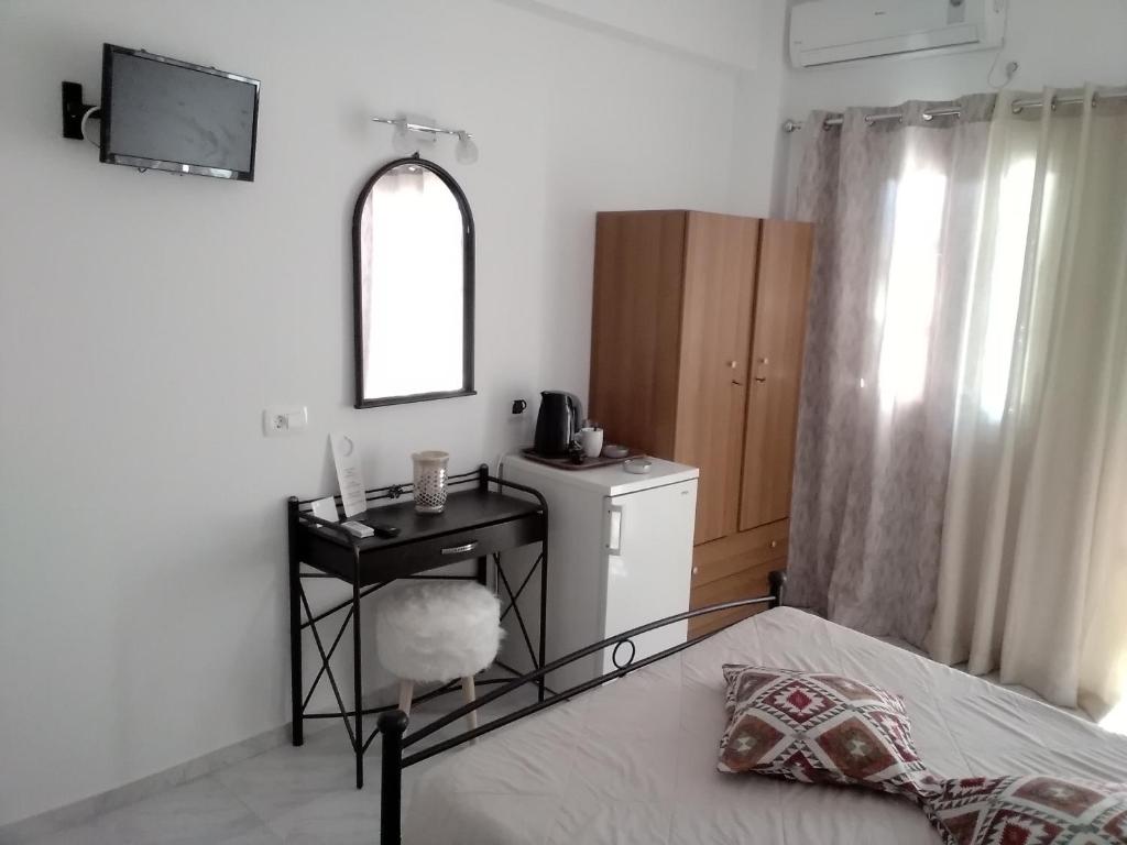 a bedroom with a bed and a sink and a mirror at Studios Irineos in Perissa