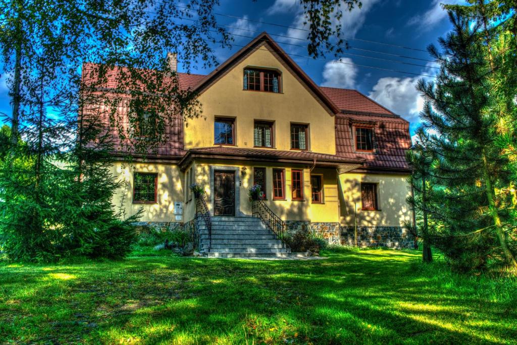 uma casa velha num relvado verde em Mała Sowa em Rzeczka