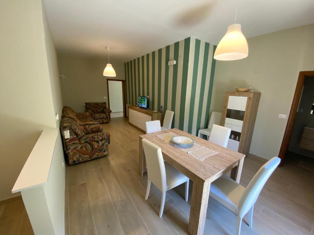 uma sala de estar com uma mesa de madeira e cadeiras em Mare e relax LA BISIERA em Montesilvano