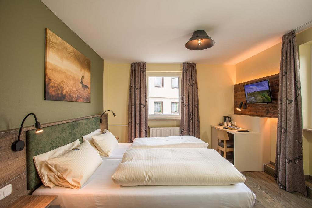 ein Hotelzimmer mit 2 Betten und einem Fenster in der Unterkunft Restaurant Grüner Baum in Leidersbach